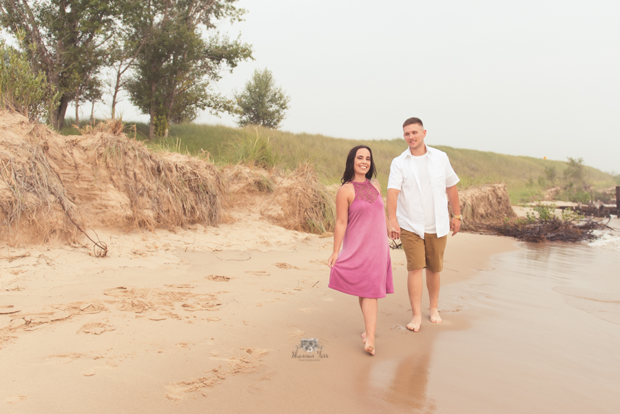 Engagement Photography in Ludington MI of couple walking on beach