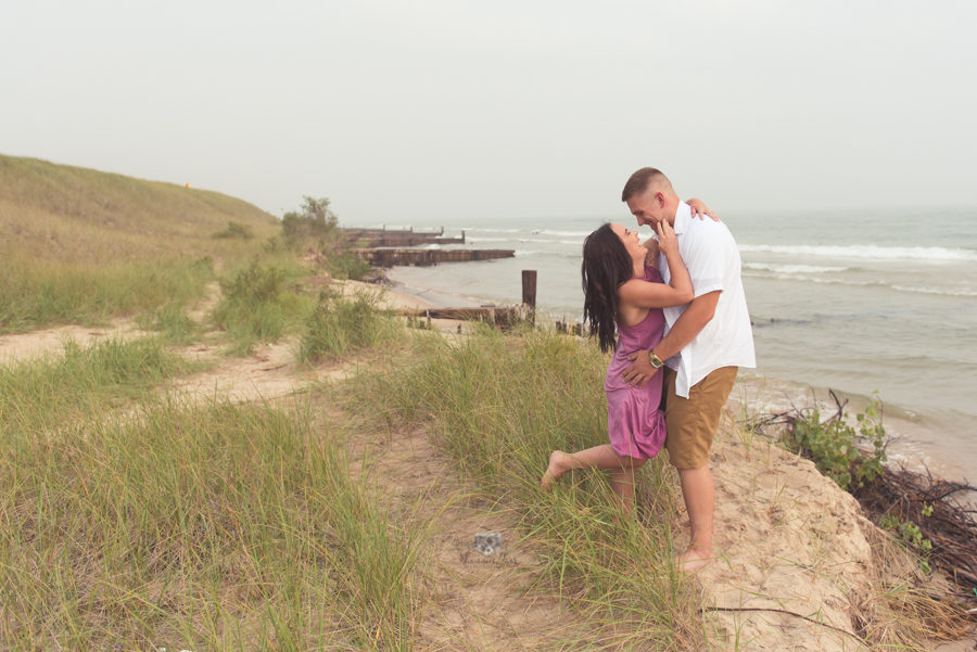 Engagement Photography in Ludington MI of couple standing on sand dunes 
