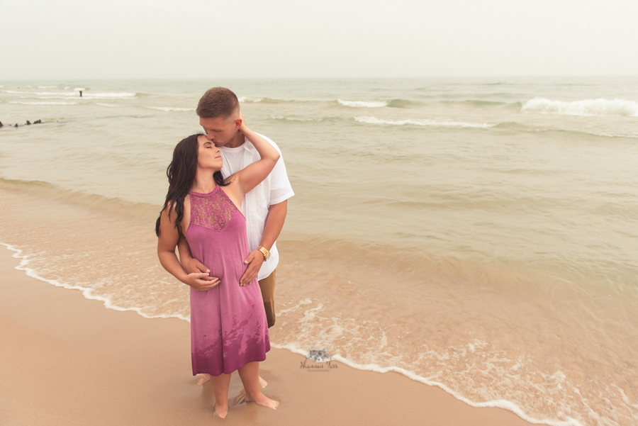 Engagement Photography in Ludington MI of guy kissing bride to be softly