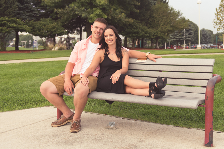 Engagement Photography in Ludington MI of couple sitting on bench at park 