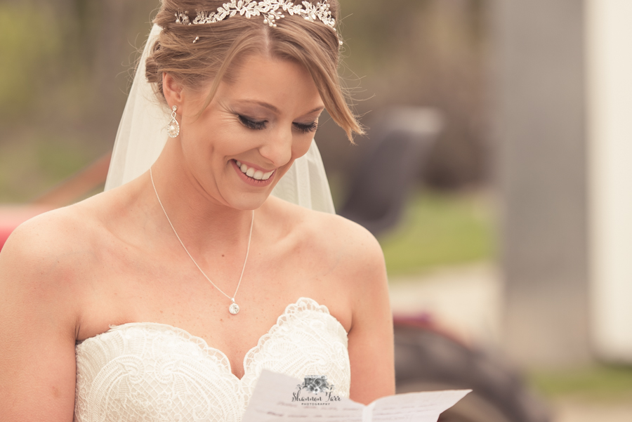 Bride smiling while reading letter from groom