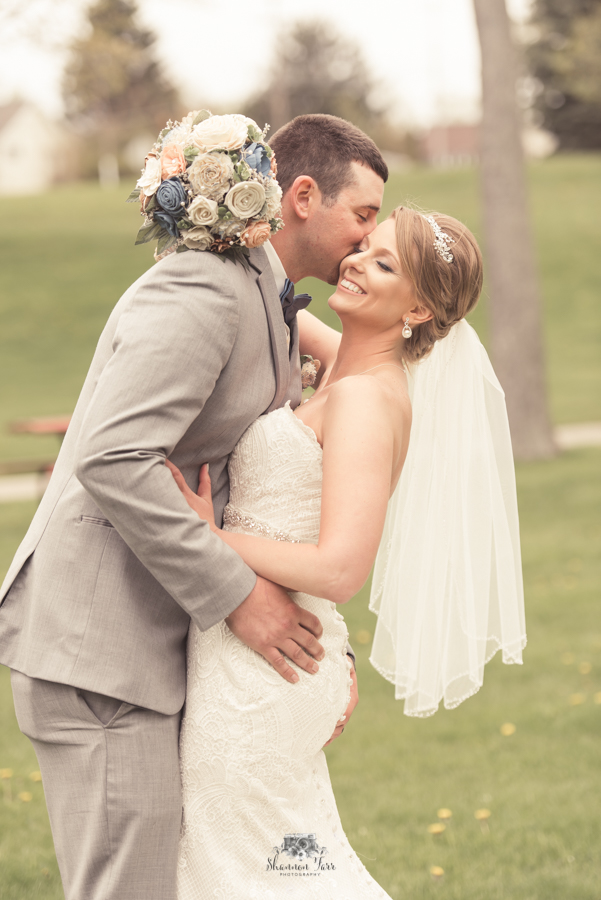Groom kissing bride at Iron Park