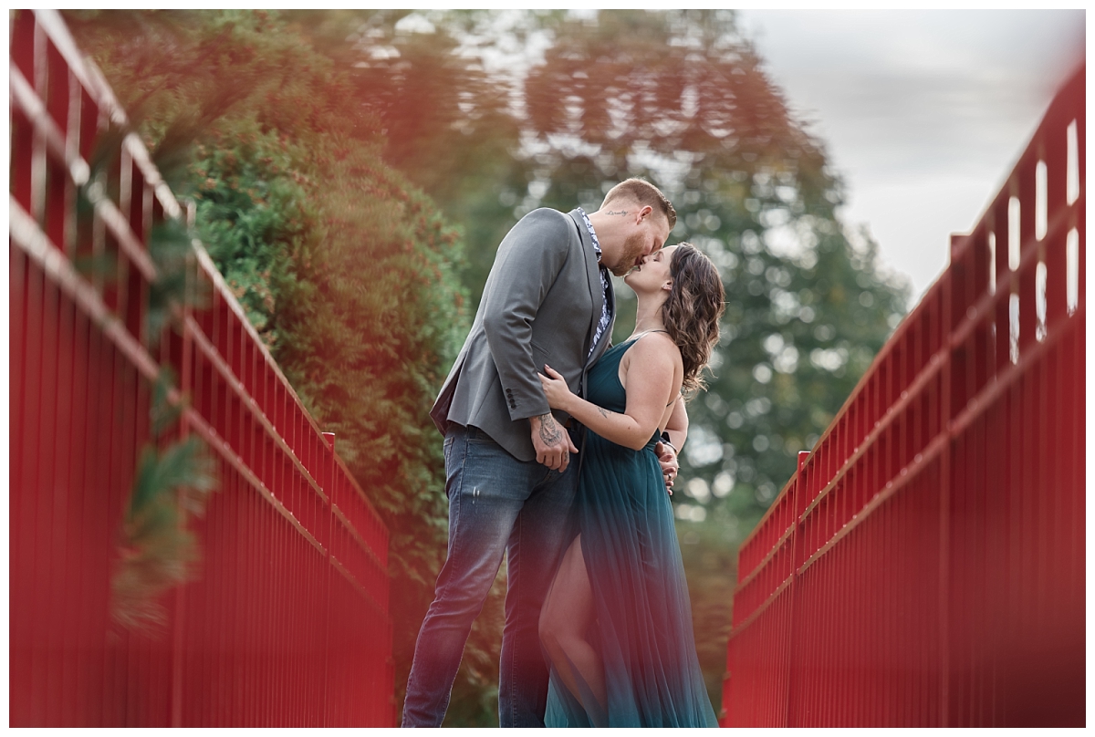 couple kissing on red bridge at dow gardens